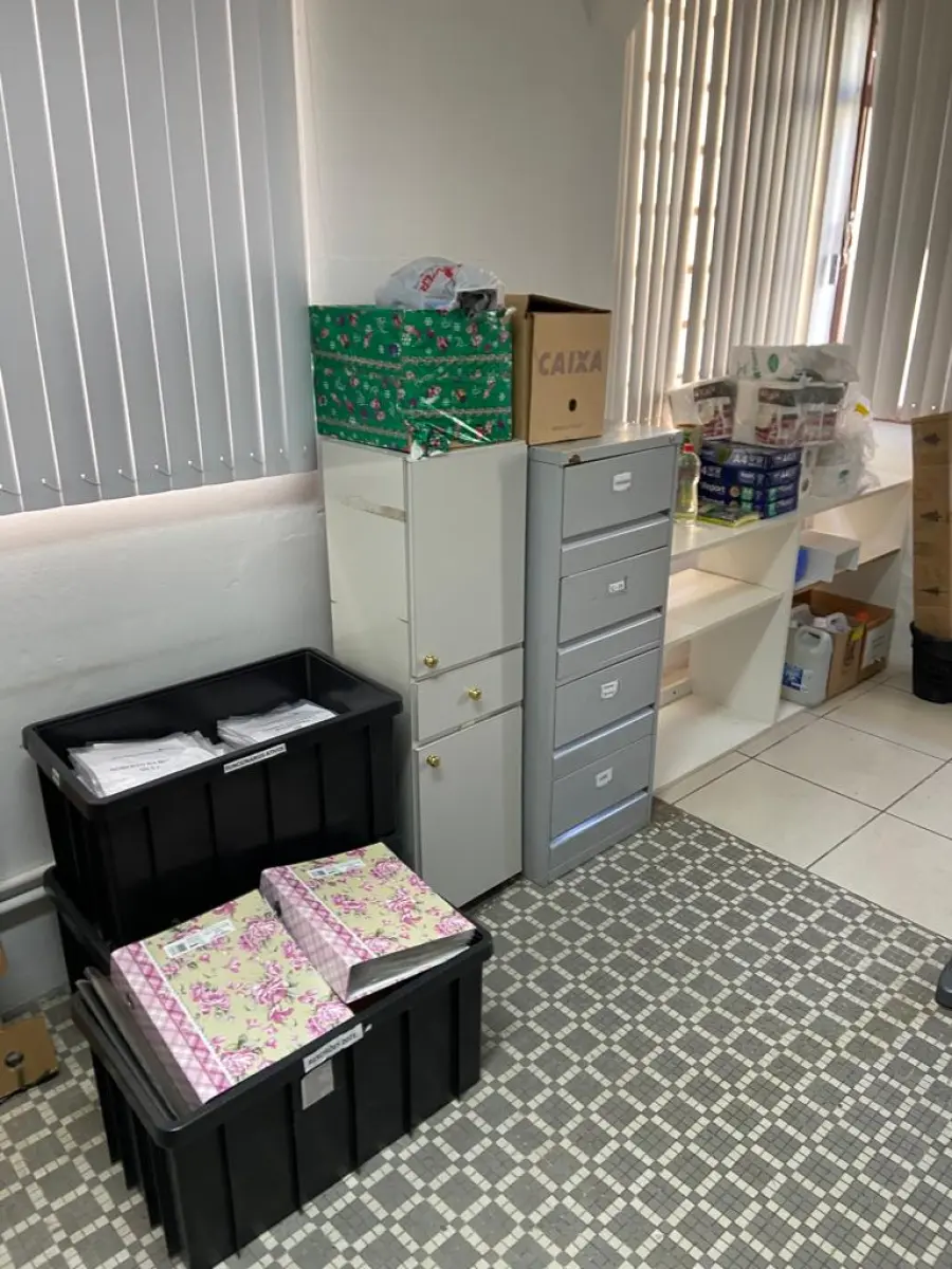 LOTE 018 - Uma mesa reta, uma mesa em L, uma mesa auxiliar, um arquivo em metal, um armário em madeira, uma estante com três nichos, dois armários de metal, materiais diversos de escritório e limpeza e dois telefones intelbrás.