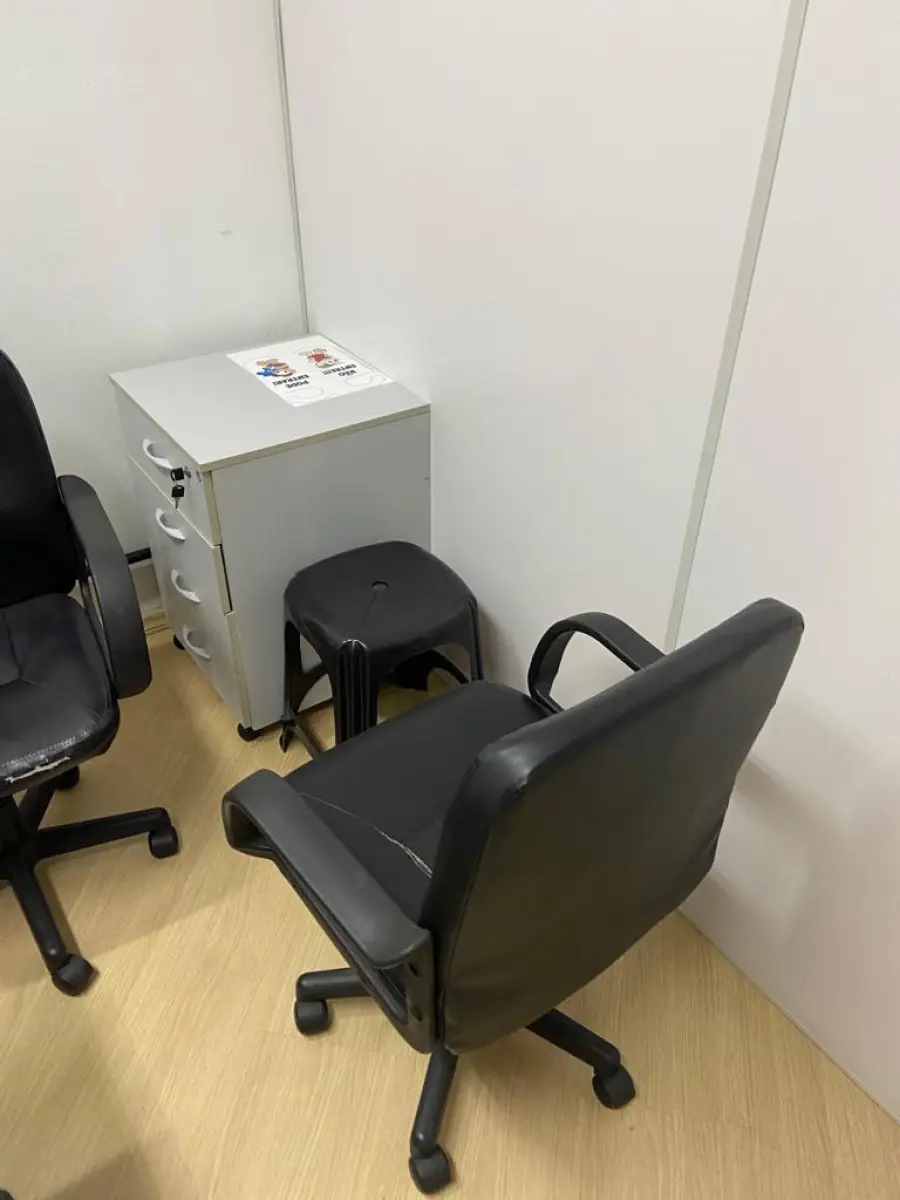 LOTE 016 - Uma mesa em L, um gaveteiro, uma mesa auxiliar, quatro cadeiras de escritório, duas poltronas de espera, um cabideiro, uma banqueta de plástico e um telefone Intelbras.