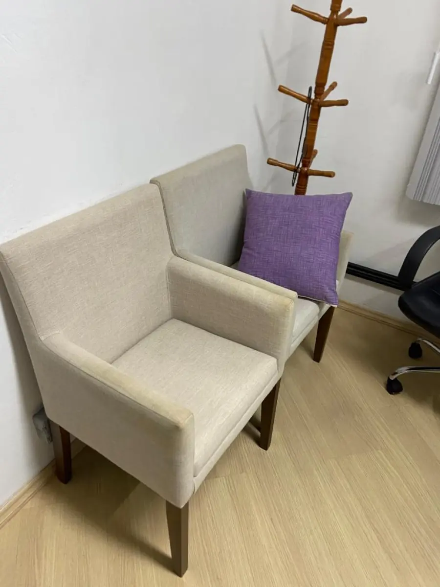 LOTE 016 - Uma mesa em L, um gaveteiro, uma mesa auxiliar, quatro cadeiras de escritório, duas poltronas de espera, um cabideiro, uma banqueta de plástico e um telefone Intelbras.